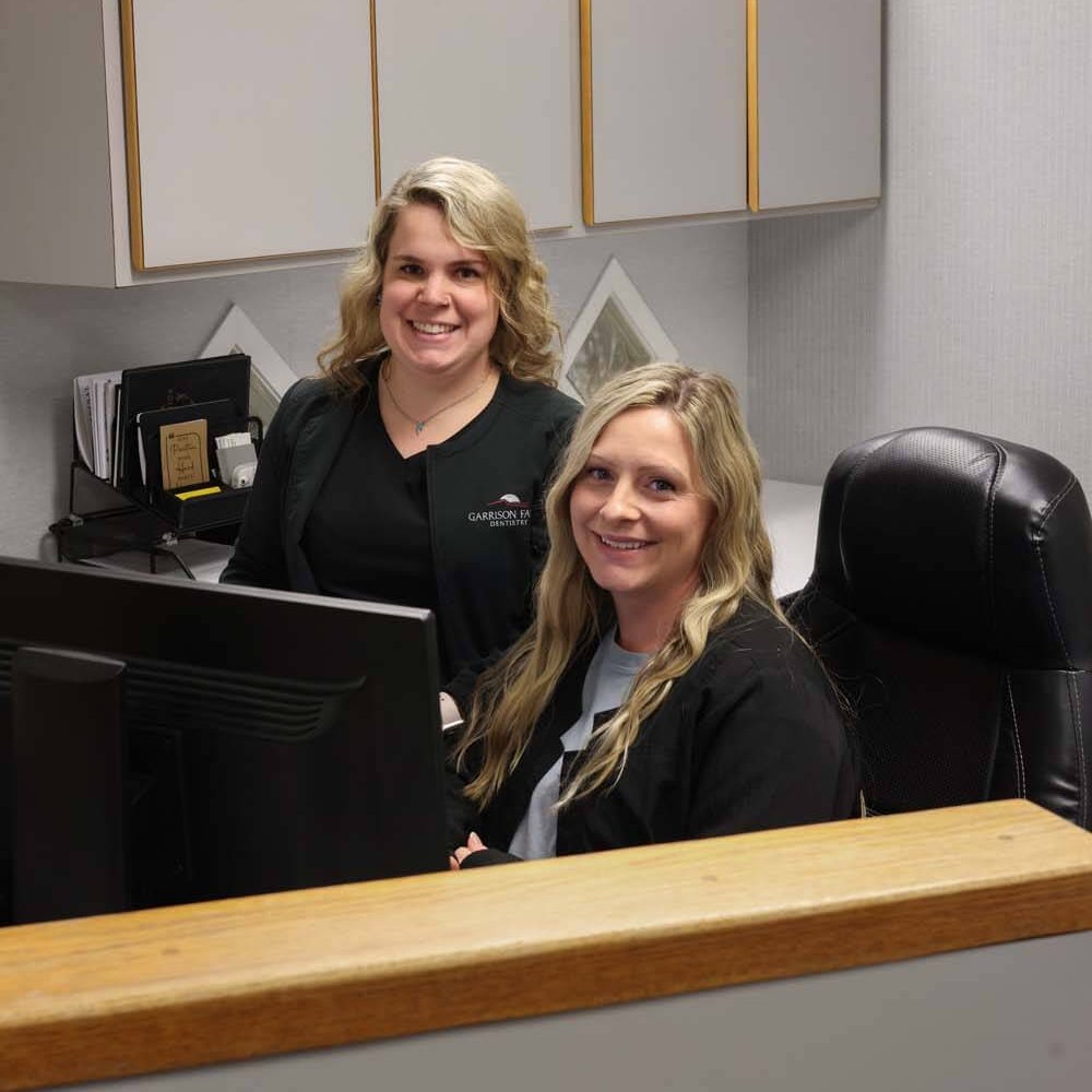 2J8A0420 Employees at front desk smiling at camera